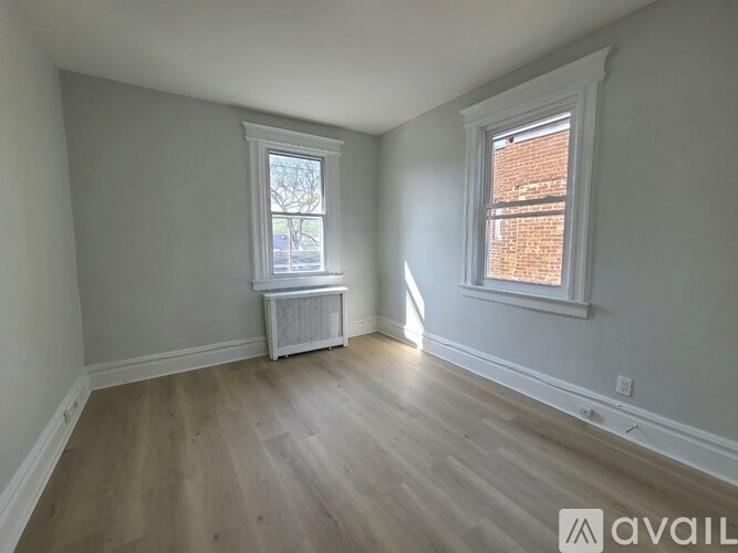 A room with a window and a radiator on the floor.