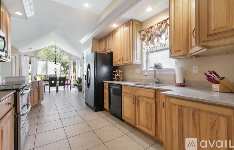 A kitchen with wooden cabinets and black appliances.