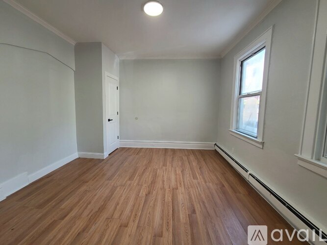 A room with wooden flooring and a window.