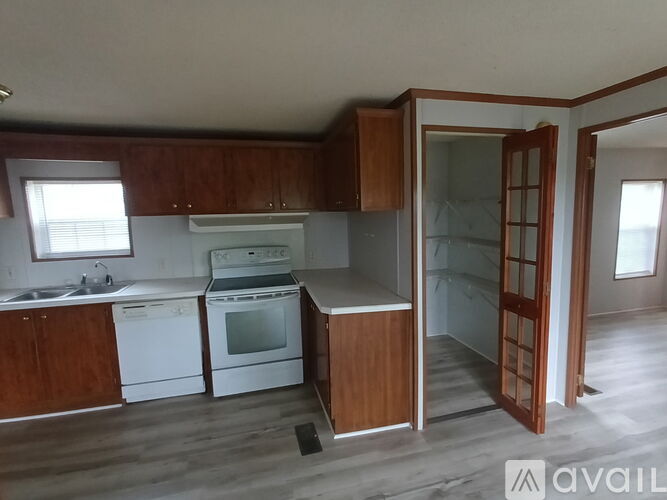 A kitchen with wooden cabinets and a white dishwasher.