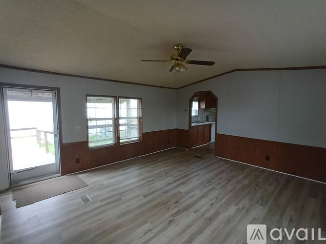 A room with wooden flooring and a ceiling fan.