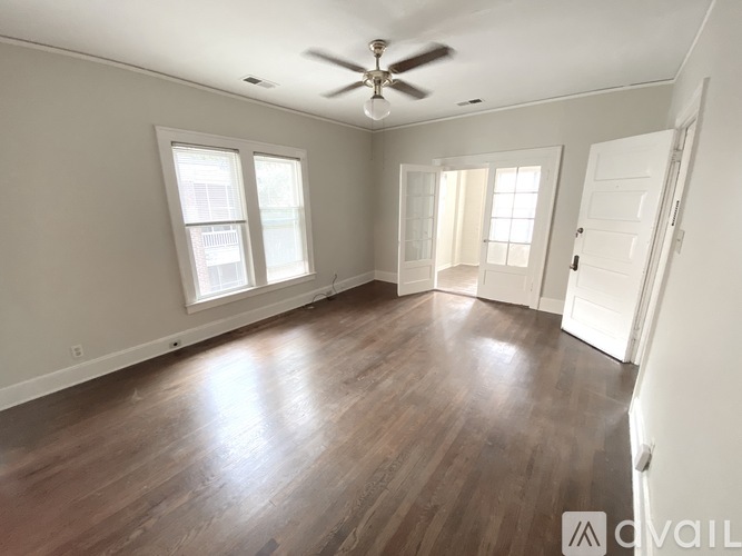 A room with a ceiling fan and wooden flooring.