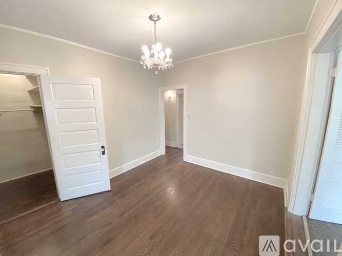 A room with a chandelier and a white door.