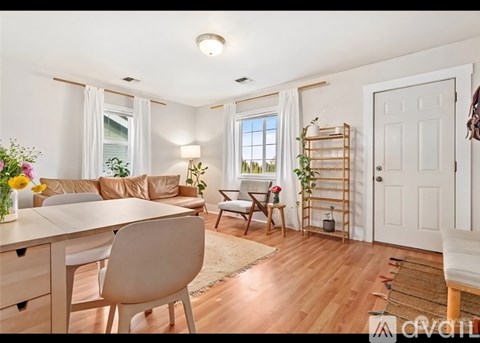 A well-lit living room with a dining table and chairs.