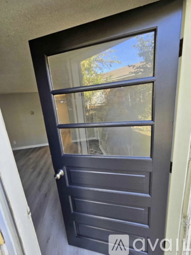 A black door with a glass window and a handle.