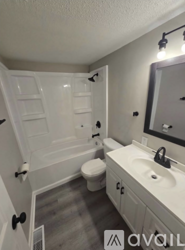 A bathroom with a toilet, sink, and bathtub.