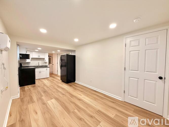 A kitchen with black appliances and wooden floors.