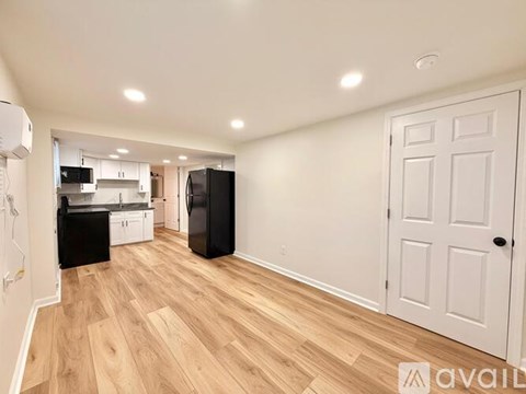 A kitchen with black appliances and wooden floors.