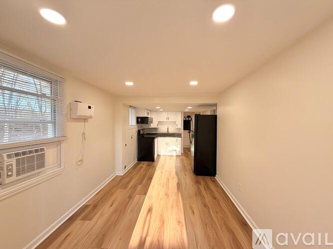 A long, narrow room with wooden floors and white walls.