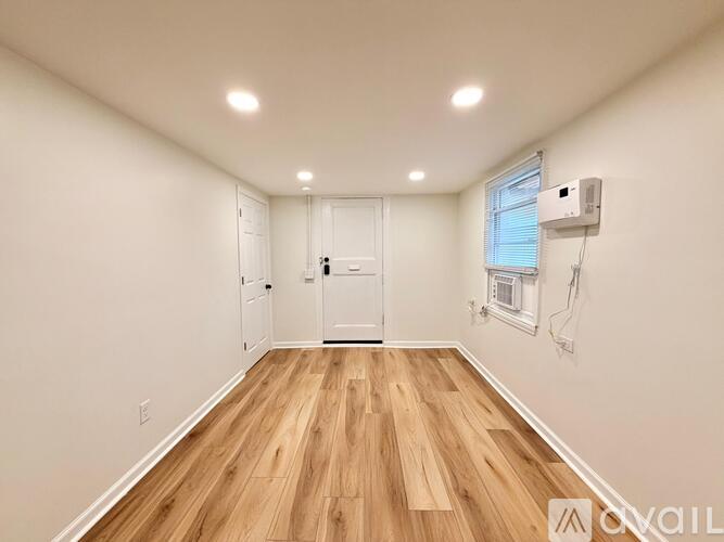 A room with wooden flooring and a white door.