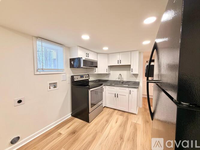 A kitchen with black appliances and white cabinets.