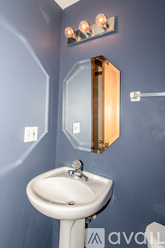 A bathroom with a white sink and a mirror above it.