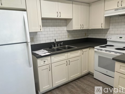 A kitchen with white appliances and cabinets.