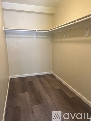 A room with a white wall and wood flooring.
