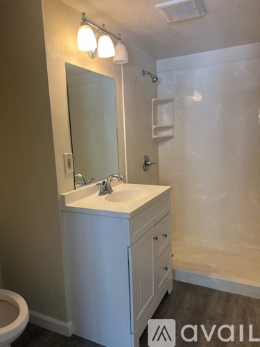 A bathroom with a white sink and a toilet.