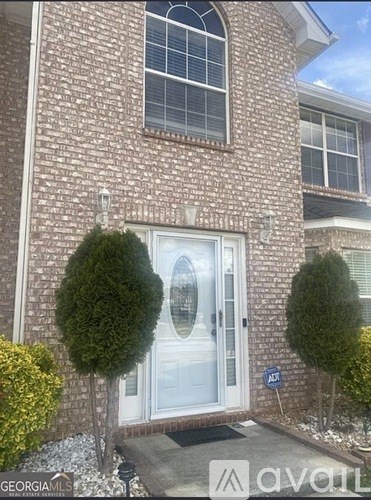 A house with a white door and a sign that says "avail" in front of it.