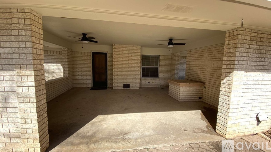 A spacious room with a concrete floor and brick walls.