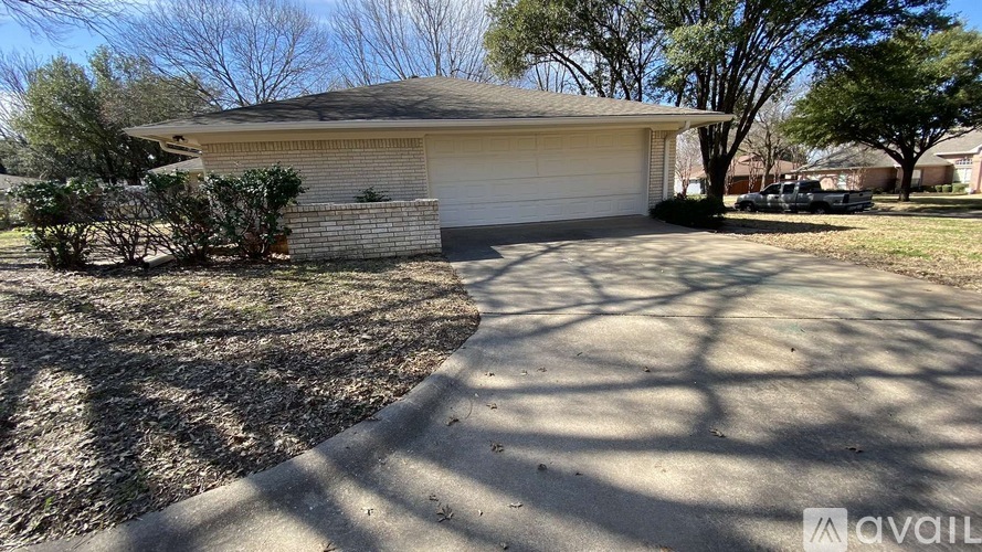 A house with a garage and a driveway in front of it.