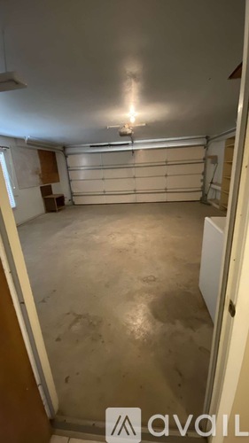 A large empty garage with a single light on.