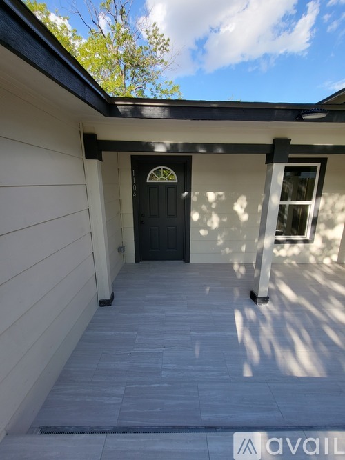 A house with a black door and a window with a white frame.
