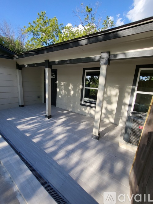 A sunny day at a house with a covered patio.