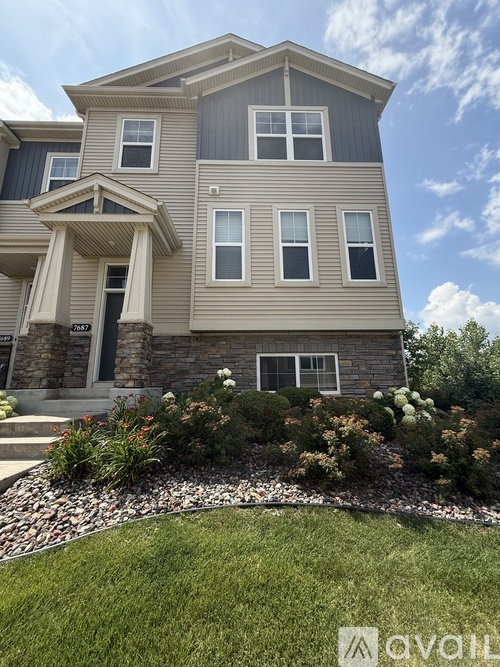A grey house with a white window and a door.