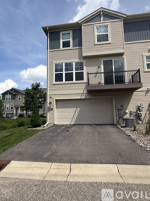 A two-story house with a garage and a balcony.