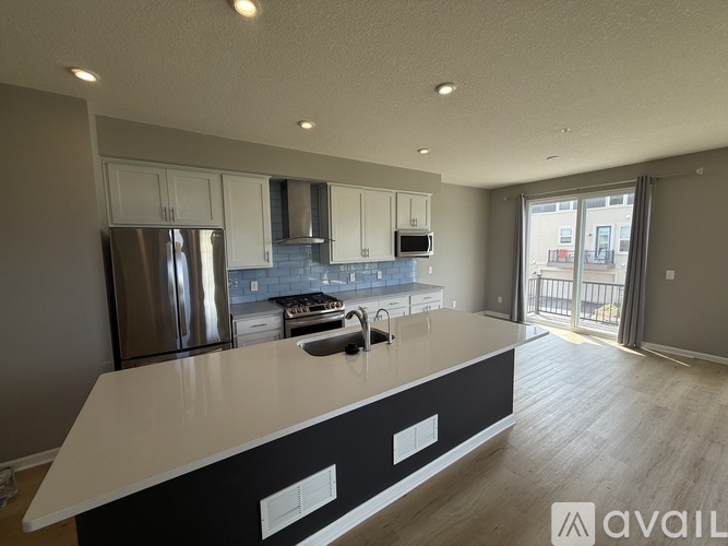 A modern kitchen with a stainless steel refrigerator and a white countertop.