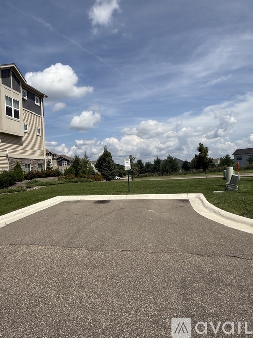 A residential area with apartment buildings and a paved area in the foreground.