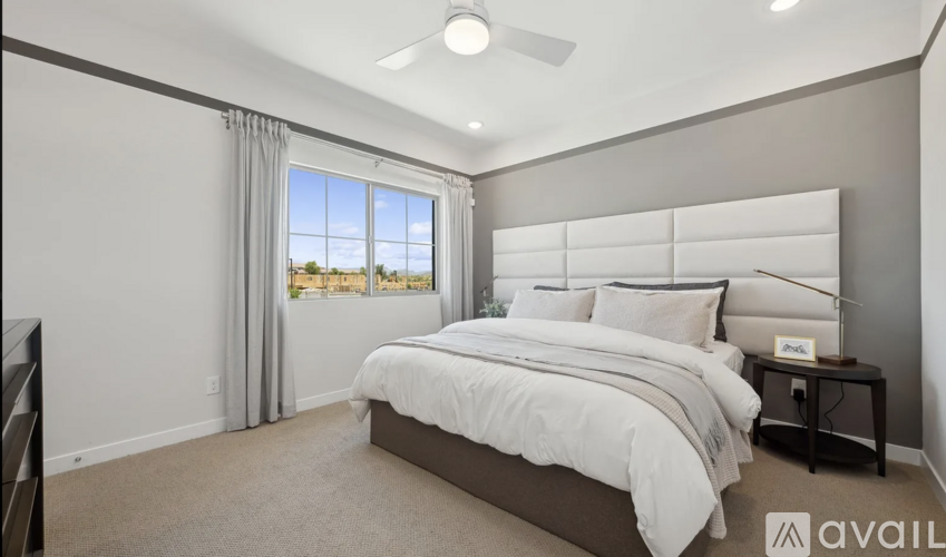 A bedroom with a large bed and a ceiling fan.