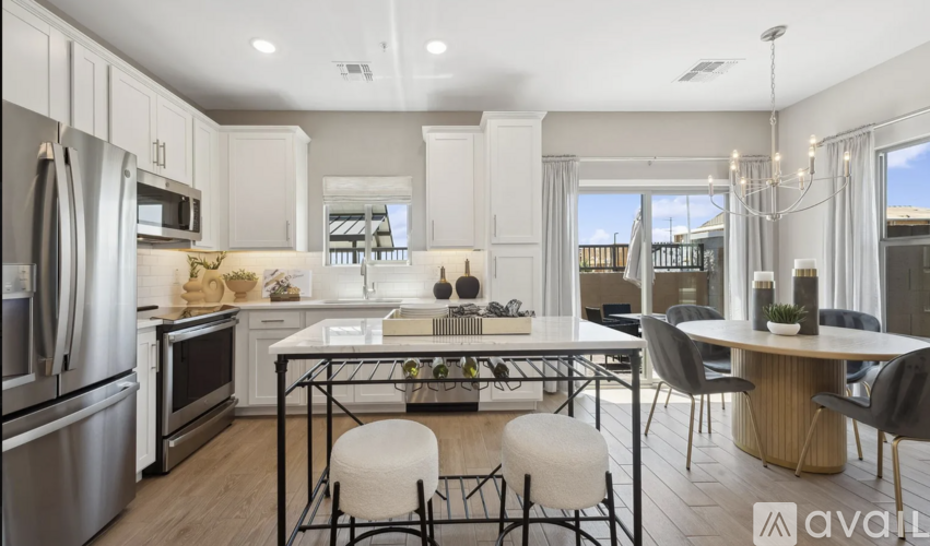 A modern kitchen with a dining table set for two.