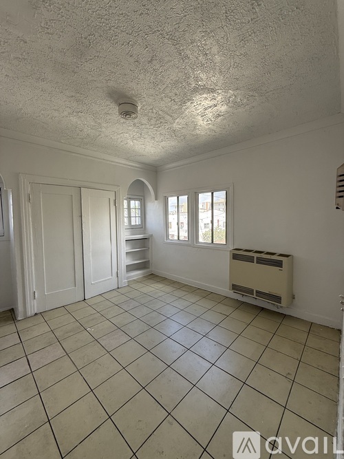 A room with a tiled floor and a window with blinds.
