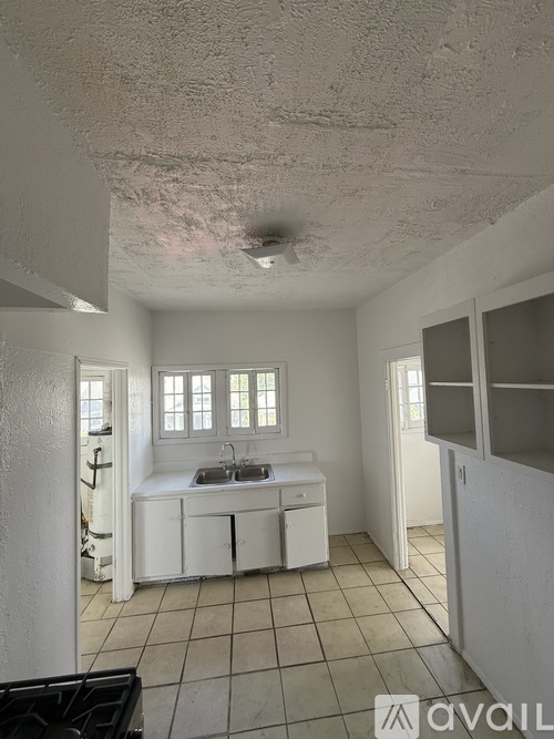 A small kitchen with white cabinets and a sink.