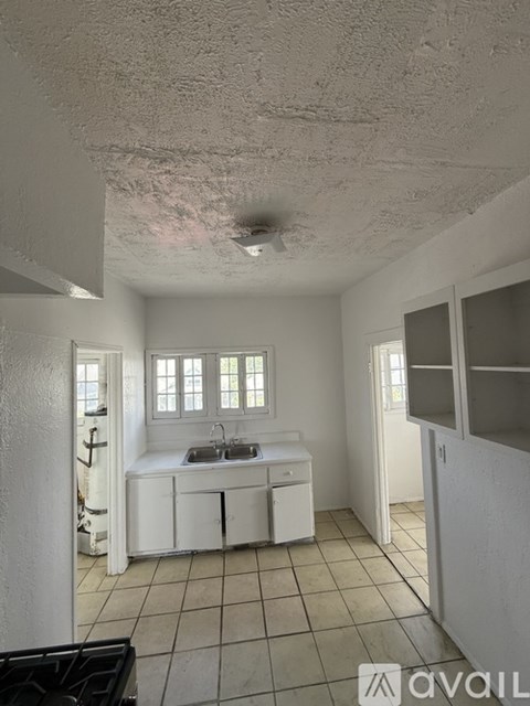 A small kitchen with white cabinets and a sink.
