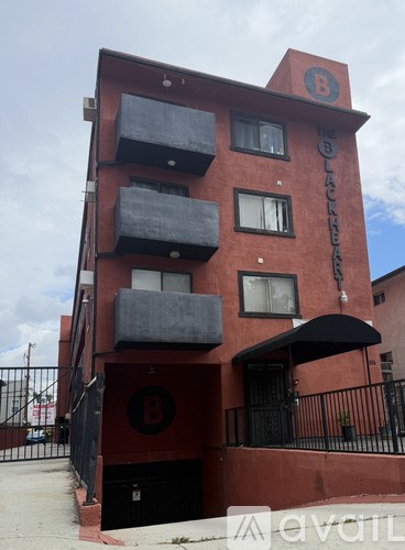 A red building with a black fence in front.