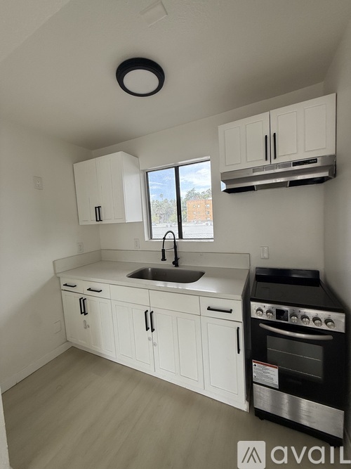 A kitchen with white cabinets and a black oven.