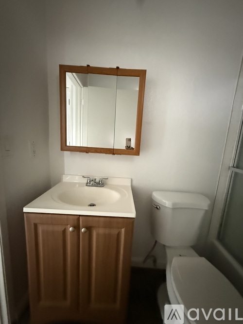 A bathroom with a sink, toilet and mirror.