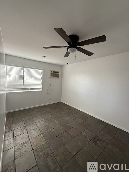 A room with a ceiling fan and tiled floor.