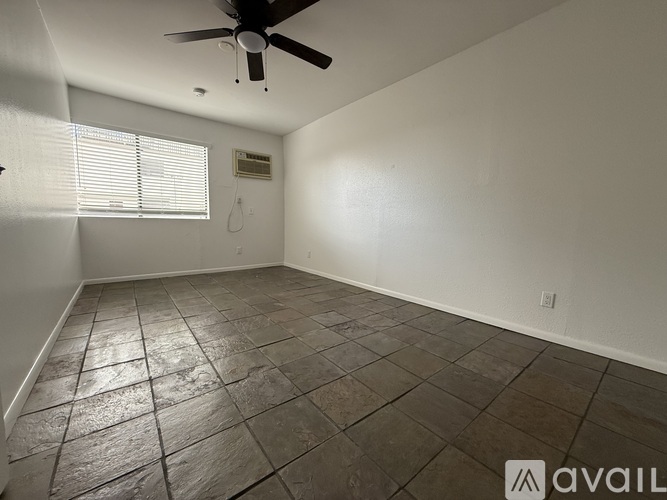 A room with a ceiling fan and tile flooring.