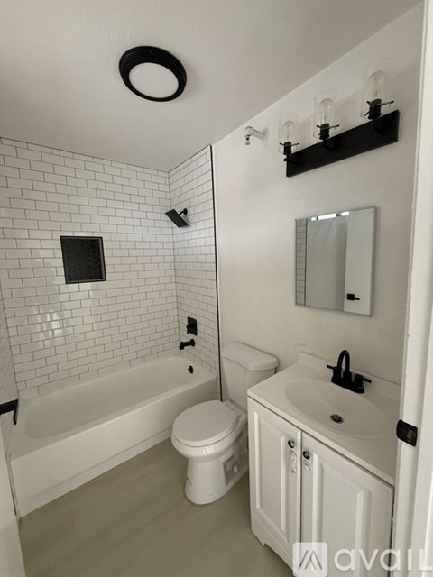 A white bathroom with a toilet, sink, and bathtub.