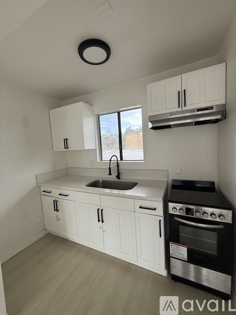 A kitchen with white cabinets and a black oven.