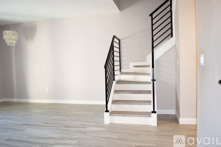 A staircase with a black railing and white steps.