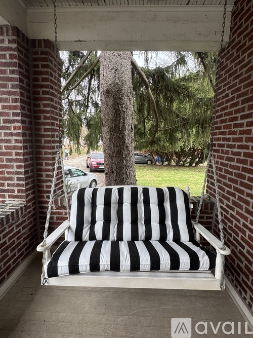 A black and white striped chair is on a porch.