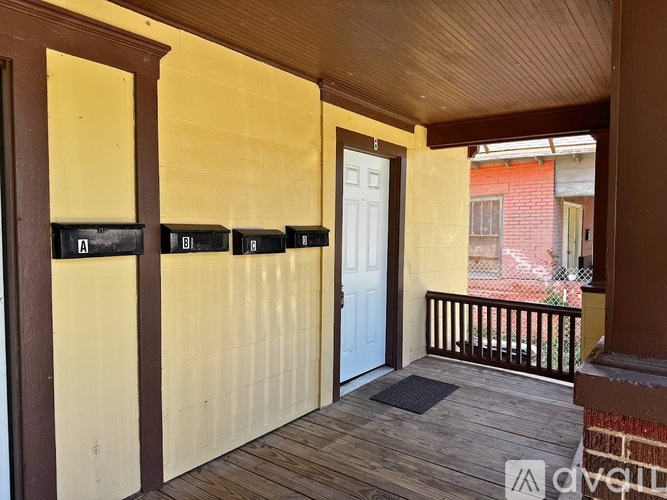 A balcony with a white door and a black mat.