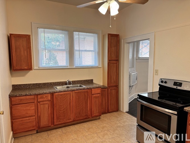 A kitchen with wooden cabinets and a black stove top oven.