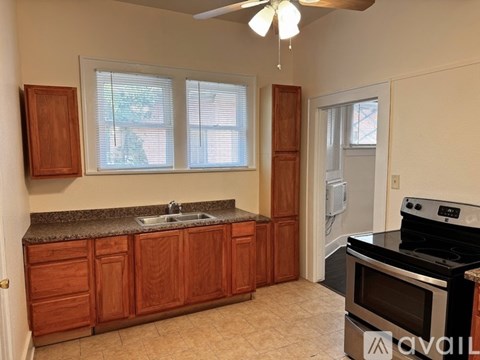 A kitchen with wooden cabinets and a black stove top oven.