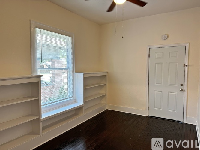 A room with a window, a door, and a ceiling fan.