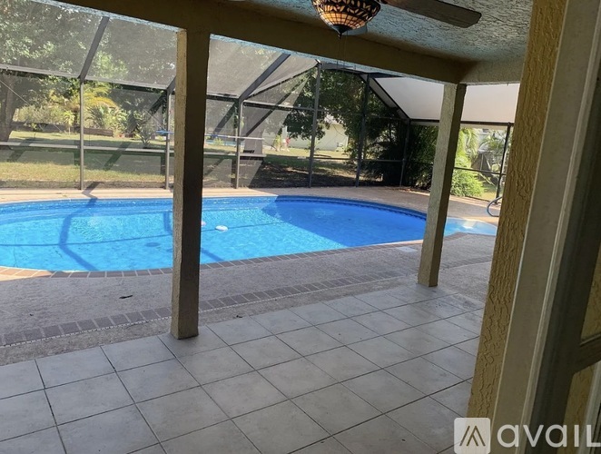 A pool inside a house with a ceiling fan.