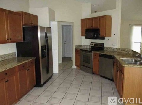 A kitchen with brown cabinets and black appliances.