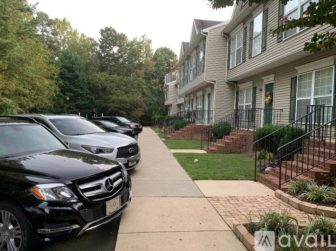 A row of cars parked in front of apartment buildings.